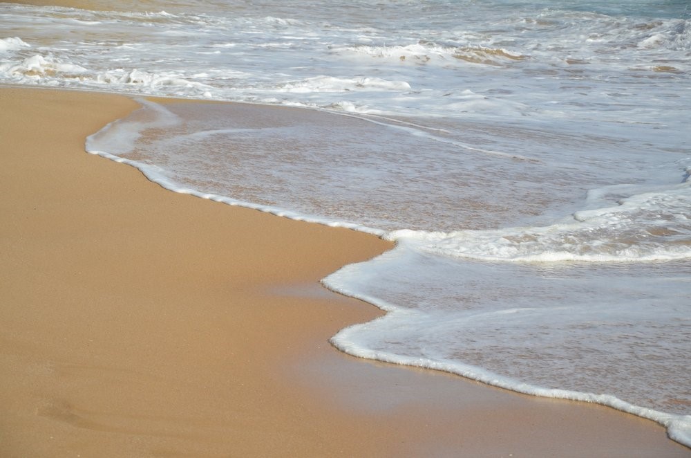 Ruhige Wellen am Sandstrand